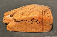 Closed view of the wooden puzzle box showing natural wood grain and puzzle seams.