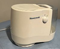 Side view of the Honeywell table-top humidifier showing the water tank, brand name, and control knob.
