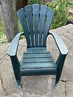 Front view of one green resin Muskoka chair showing slatted back and seat with wide armrests.
