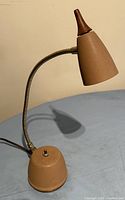 Small coppertone desk lamp shown turned off