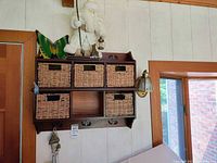 Full view of stacked wooden cubby shelves with wicker drawers, Santa figurine, butterfly decor, wind chime