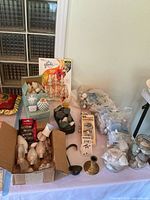 Overview of lot on table showing candles, Glade refills, candle holders, bulbs, decor