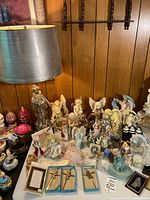 Wide view of table with angel, nun figurines, lamp and boxed crucifixes