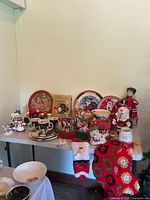Full lot on table with plates, mugs, figurines, stocking, crochet mat