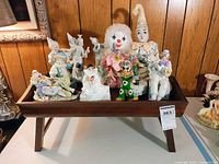 All figurines and dolls arranged on wooden tray, frontal view