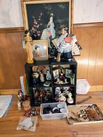 overall lot showing framed art, dolls, cubby shelves with ceramics and figurines, additional pieces on floor