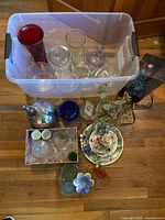 Overall lot showing glassware in tote, metal pitcher, ceramic centerpiece, lamp, assorted decor