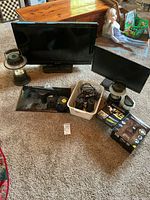 Group view showing TV, two monitors, two lanterns, dashcam box, basket of cables