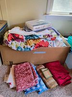 Overall lot in box with assorted linens, packaged protector visible