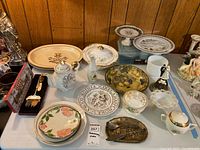 Front view showing main items including teapot, platters, commemorative plates, cake server set and brass fish dish