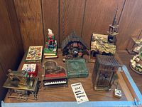 Overview of assorted music boxes, figurines and trinket boxes on tabletop