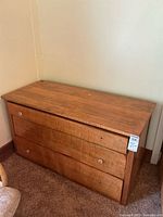 Full view of wooden chest of drawers against wall
