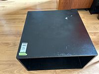 Top and side view of black laminate cube coffee table showing overall form and surface scratches