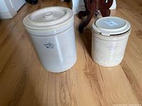 Both crocks side by side showing size difference and lids