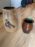 Overview of beige stoneware butter churn and small brown glazed ceramic jar