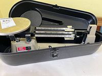 Ohaus triple beam balance scale inside carrying case, pan visible