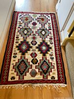 Full view of the kilim rug showing its size, general design, and fringe on one short end.