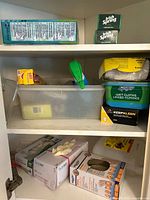 Cabinet shelves with soap, Swiffer cloths, plastic wrap and multiple glove boxes