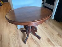 Full view of table showing oval top and pedestal base