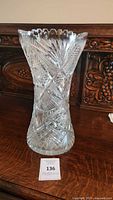 Clear crystal corset vase with detailed pinwheel and hobstar cuts, narrow waist and flared scalloped lip.