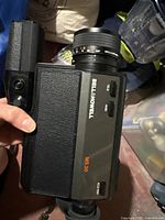 Close-up of the camera body showing branding, zoom lens details, and side controls.