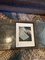 Framed black and white photo on a glass table with surrounding room decor in view