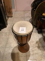 Full view of wooden African djembe drum showing natural skin drum head and rope tuning system.