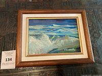 Complete view of the framed painting showing ocean storm scene with turbulent waves and signed in bottom right corner.