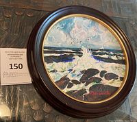 Frontal view of the framed circular seascape painting showing crashing waves, rocks, sky, birds, signature, and wooden frame with gold inner rim.
