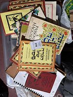 Top view of multiple Judaica books stacked in a container showing various covers including Passover Haggadah editions