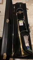 King Cleveland trombone assembled in open hard case, showing bell, slide, case lining and accessories in compartment