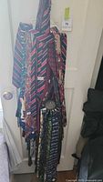 Full view of ties hanging on tie racks on a door, showing varied tie colors and designs with metal racks