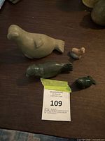 Four seal figurines displayed on dark surface, showing size and color variations