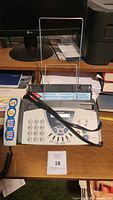 Top angled view of Brother Fax-575 fax machine on wooden desk with handset and numeric keypad visible.