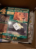 Box of four deluxe animal jigsaw puzzles, showing images of lion, leopard, bear, and giant panda, piece counts 250 and 1000.