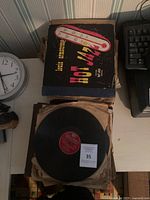 Top view of vintage vinyl record lot showing Louis Armstrong Hot Jazz vinyl album cover and one vinyl record outside the cover with a Columbia label visible