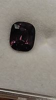 Loose electric purple cushion cut spinel on white background