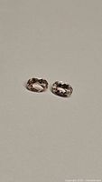 Two natural untreated champagne morganite gemstones, oval cut, approximately 6.5x4.5mm each, shown side by side.