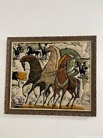 Full front view of the framed fabric art showing the stylized four horses and the textured quilted design