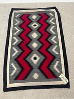 Full top view of rectangular Navajo rug on beige carpet