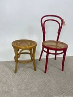 Red bentwood Thonet chair and natural wood bentwood stool on carpeted floor against white wall