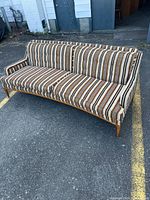 Front view of entire sofa showing striped upholstery and wood legs