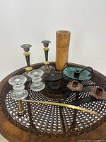 View of the entire lot on decorative metal tray showing all candleholders, pottery piece, and wooden item.
