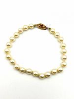 Full view of pearl bracelet in closed loop showing pearls and clasp