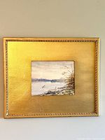 Full view of framed painting showing gold frame and artwork