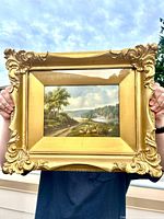 Front view of framed Henry Harold Vickers painting held outdoors
