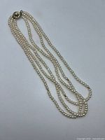 Full view triple strand pearl necklace