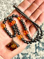 Front view of necklace showing sterling amber pendant, hematite and amber beads