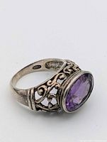 Side view of ring showing amethyst, filigree band, 925 stamp