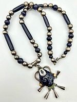 Full view of sterling silver and purple goldstone bead necklace with Aztec face pendant